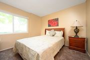 Hemet multi-family for rent - a bedroom with a bed and a nightstand at Oak Terrace Senior Apts, Hemet, 92543