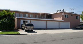 Gardena multi-family for rent - A tan house with a car parked in front.
