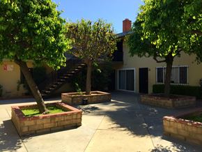 Compton multi-family for rent - A tree in a planter box is in front of a house.