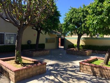 Compton multi-family for rent - A courtyard with trees and a building in the background.