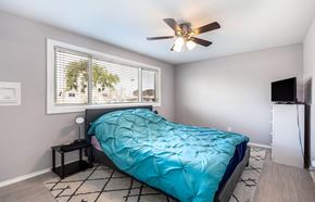 Long Beach multi-family for rent - A bedroom with a blue comforter on the bed.