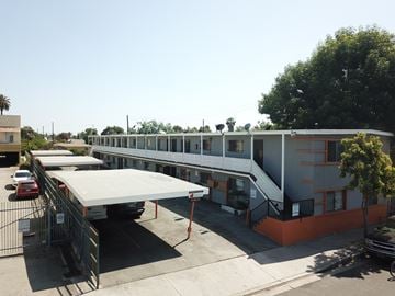 Compton multi-family for rent - A long building with a red car parked in front of it.