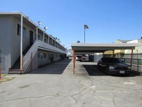 Compton multi-family for rent - A black car is parked in a parking lot.