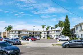 Los Angeles multi-family for rent - A parking lot with cars and apartment buildings in the background.