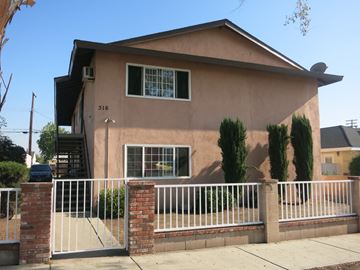 Azusa multi-family for rent - A house with a white fence and a brick pillar.