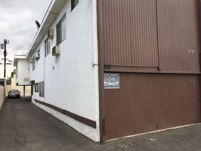 North Hollywood multi-family for rent - A white building with a brown door and a sign on it.