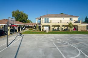 San Bernardino multi-family for rent - A basketball court is located in front of a building with a red door.