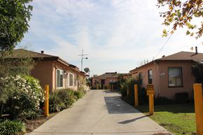 El Monte multi-family for rent - A residential street with houses on both sides and a sign on the right side of the street.