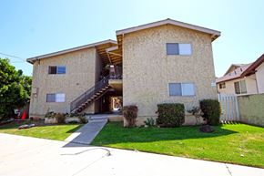 Harbor City multi-family for rent - A tan stucco house with a black metal staircase leading to the front door.