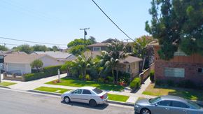 Downey multi-family for rent - A residential street with cars parked on the side.