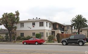 Arcadia multi-family for rent - A red car is parked on the street in front of a white house.