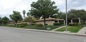 Claremont multi-family for rent - A tree in front of a house with a street in front of it.