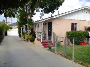 Los Angeles apartment for rent - A residential street with a house on the right and a fence in front.