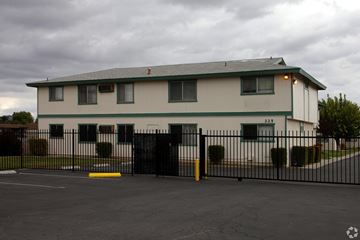 Perris multi-family for rent - A white building with a black fence in front.