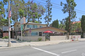 Santa Fe Springs multi-family for rent - A building with a red umbrella is situated on the corner of a street.