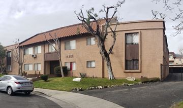 Sylmar multi-family for rent - A car is parked in front of a building with the number 14255 on it.