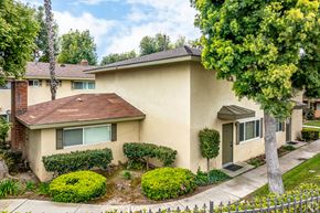 Claremont multi-family for rent - A house with a brown roof and a white fence.