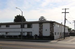 El Monte multi-family for rent - A white building with a black roof and a stone pillar on the side.