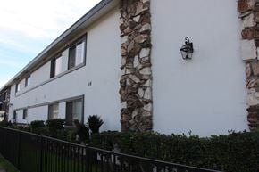 El Monte multi-family for rent - A white house with a stone pillar and a black fence.