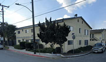 Compton multi-family for rent - A street view of a residential area with a house, cars, and trees.