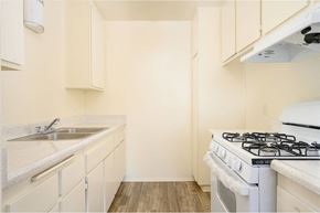 Hemet apartment for rent - a kitchen with white cabinets and a white stove top oven at Villa Hemet, Hemet, CA 92543