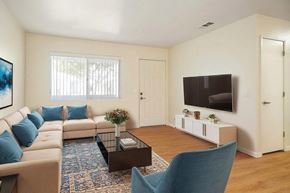 Hemet multi-family for rent - A living room with a sofa, a coffee table, a chair, and a television.
