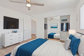 Norwalk apartment for rent - A bedroom with a bed, a dresser, a mirror, and a ceiling fan.