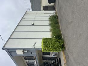 San Fernando multi-family for rent - A grey building with a green bush on the side.