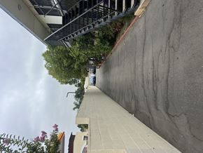 San Fernando multi-family for rent - A concrete staircase with a metal railing on the left side and a wall on the right side.
