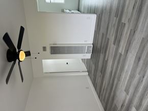 San Fernando multi-family for rent - A white air conditioner unit is mounted on a wall with a fan on the left side.