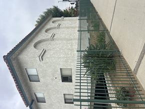 Sylmar multi-family for rent - A building with a green fence in front of it.