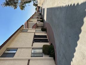 Paramount multi-family for rent - A tall building with a row of windows and balconies.