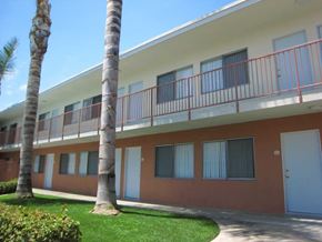 Pomona multi-family for rent - A building with a red and white exterior and a balcony with red railings.
