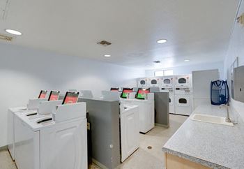 A laundry room with washers and dryers