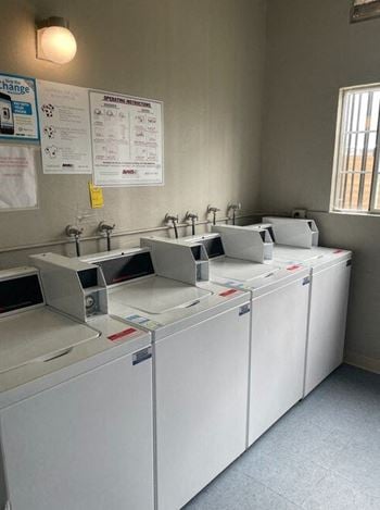 A row of white washing machines sitting next to each other