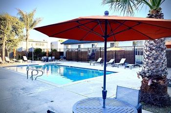 A swimming pool with a table and umbrella