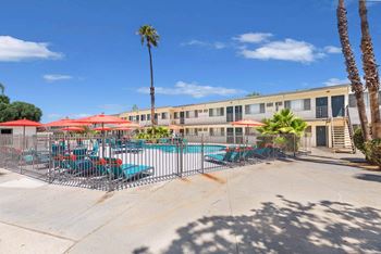 Our apartments have a pool and patio with chairs and umbrellas