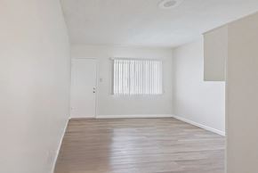 Hawthorne multi-family for rent - A room with a wooden floor and a window with blinds.