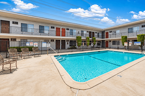 Bellflower multi-family for rent - A swimming pool in front of apartment buildings.