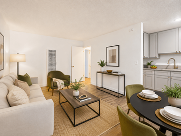 Bellflower multi-family for rent - A living room with a white couch, a coffee table, and a dining table set for two.