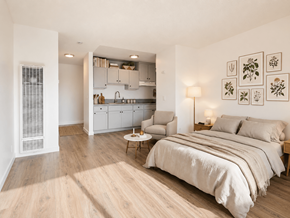 Bellflower multi-family for rent - A bedroom with a large bed and a kitchen area in the background.