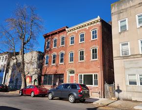 Trenton apartment for rent - A red brick building with a green lawn in front.