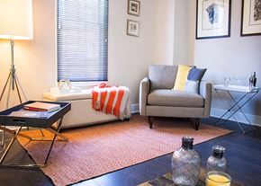 Trenton apartment for rent - A living room with a grey couch, a coffee table, and a lamp.