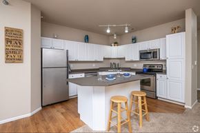 Apple Valley townhouse for rent - A kitchen with white cabinets and a wooden island.