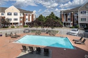 Apple Valley townhouse for rent - A swimming pool surrounded by chairs and trees in front of apartment buildings.