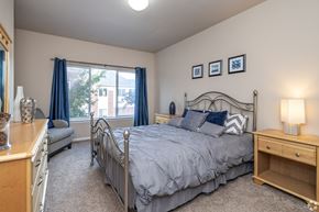 Apple Valley townhouse for rent - A bedroom with a large bed and a window with blue curtains.