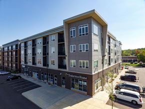 Eagan apartment for rent - a large apartment building with a parking lot in front of it at The Flats at Cedar Grove, Minnesota, 55122