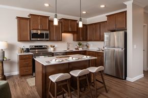 Prior Lake apartment for rent - A kitchen with wooden cabinets and a stainless steel refrigerator.