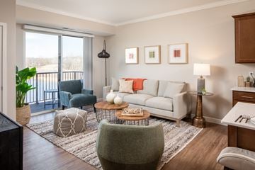 Prior Lake apartment for rent - A living room with a white couch and a grey ottoman.