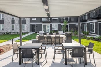 Outdoor courtyard with dining tables and grilling stations